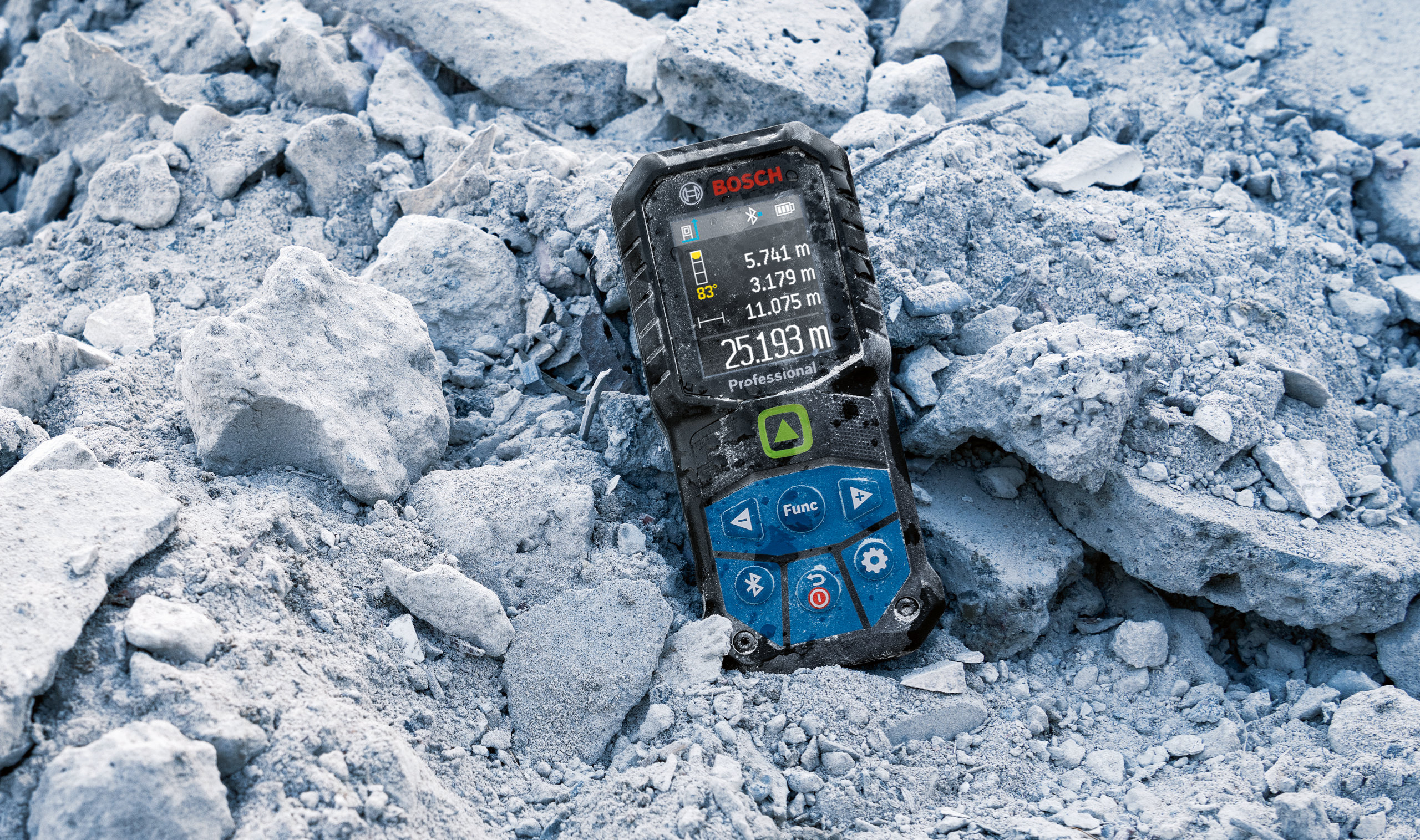 Bosch 50m Laser Measure - Rugged Rubber Housing Ruggedized rubber housing on a Bosch 50m laser measure sitting in construction site debris.