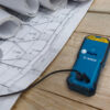 Bosch 50m Laser Measure - USB Charging Port Close-up of the USB charging port on a Bosch 50m laser measure next to site plans.