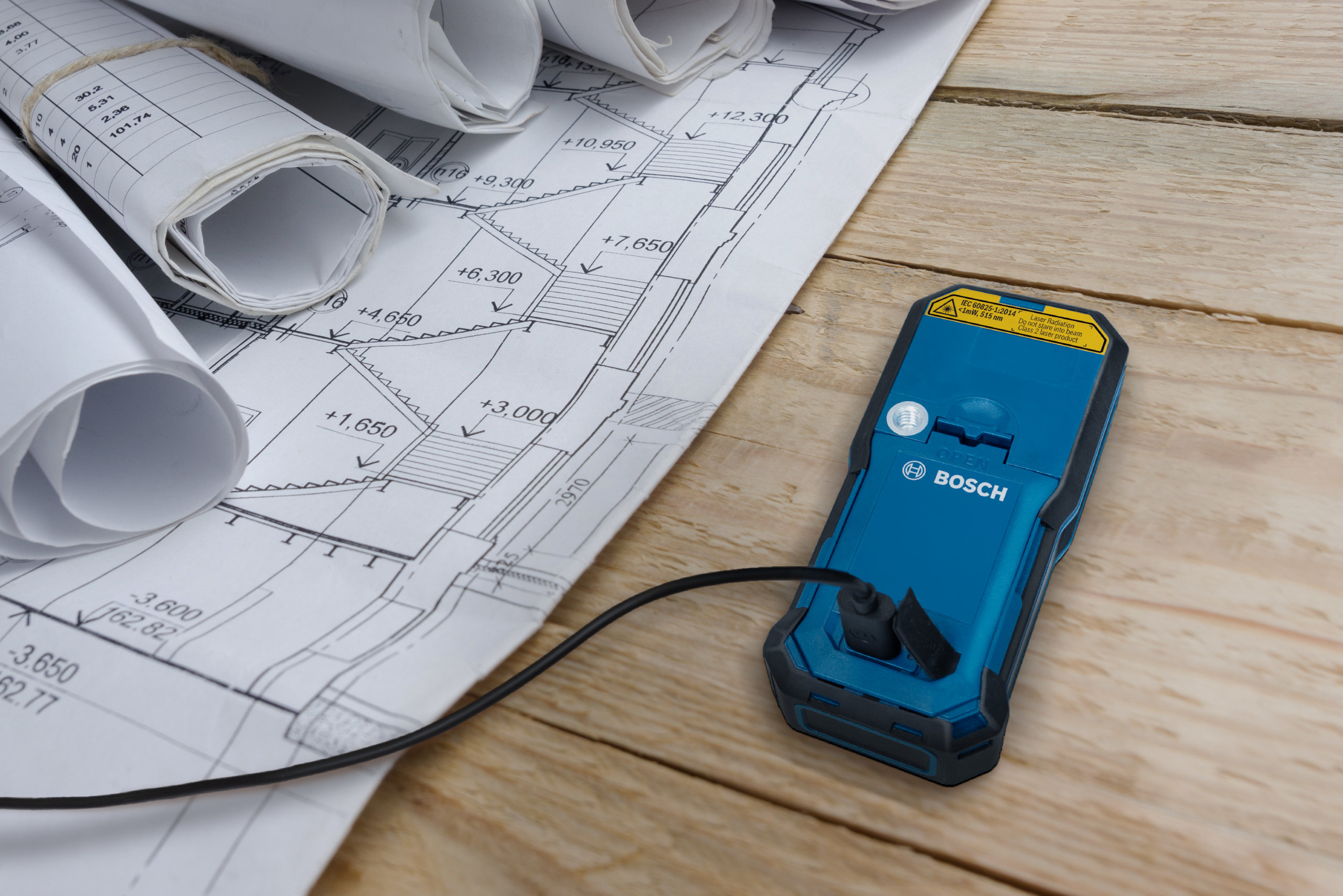 Bosch 50m Laser Measure - USB Charging Port Close-up of the USB charging port on a Bosch 50m laser measure next to site plans.