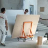 Mondelin 900kg Board Trolley – Operator View Site Handling Tradesmen maneuvering a Mondelin 900kg board trolley loaded with plasterboard panels through a building interior, available for hire at Weller Hire.